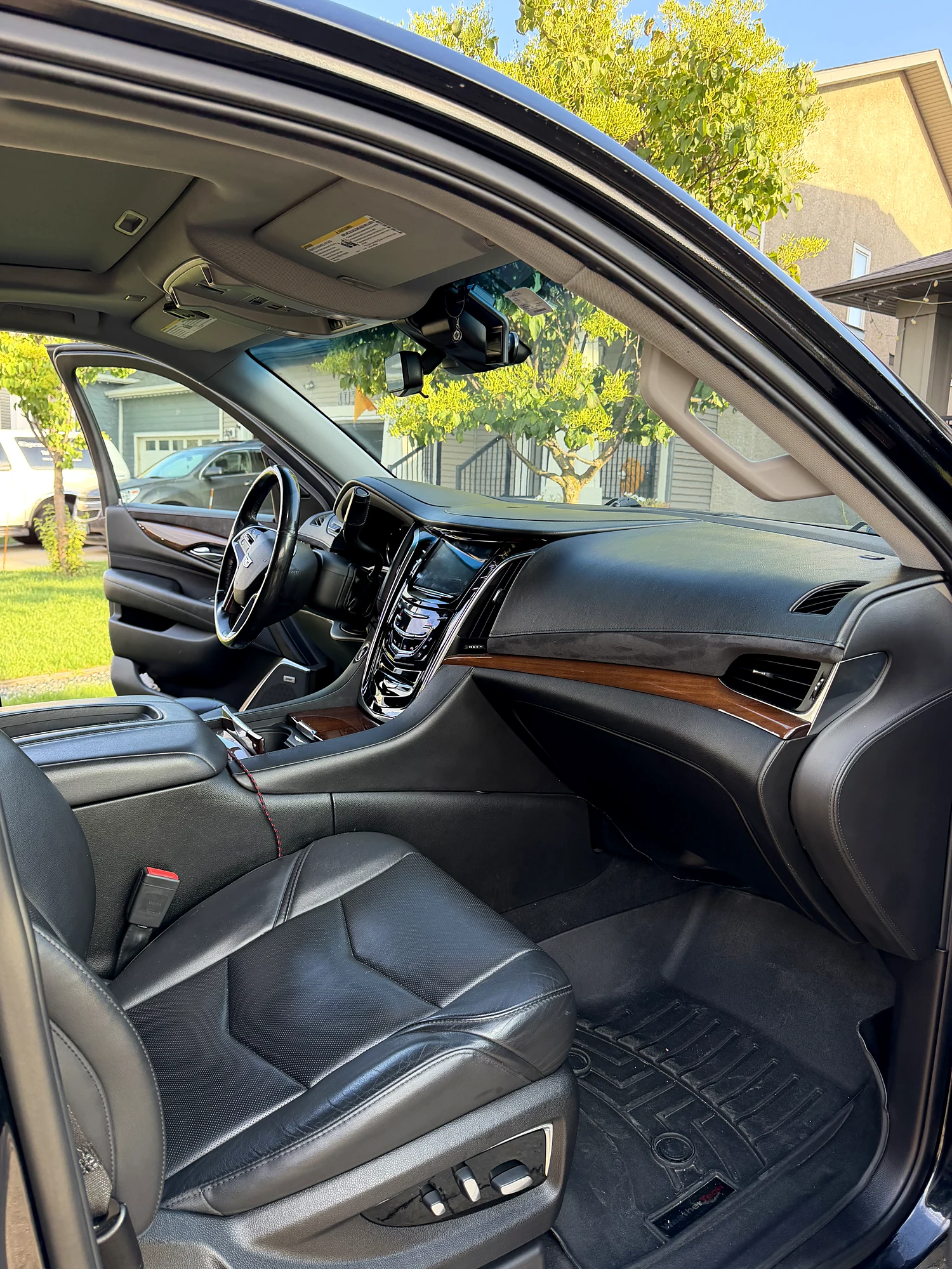 Front cabin of the Cadillac Escalade ESV: black leather, wood trim and the centre console