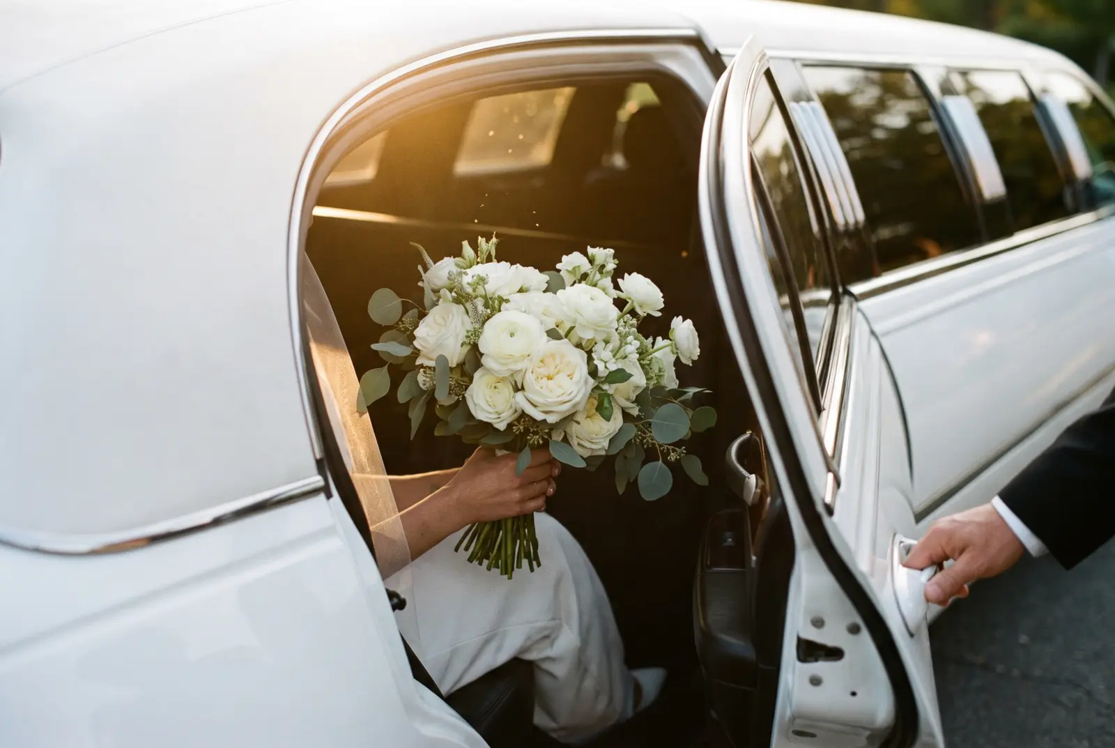Bouquet near the open door of the white stretch limousine